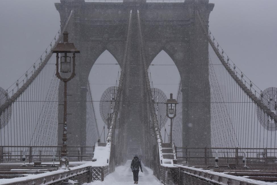 Một người đang đi bộ trên cây cầu Brooklyn khi  bão tuyết ở New York đổ về. Ảnh Reuters